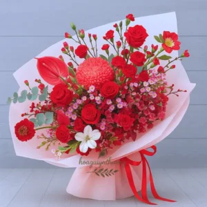 Bó hoa sinh nhật nghệ thuật với tone đỏ nổi bật và giấy gói hồng pastel dịu dàng.