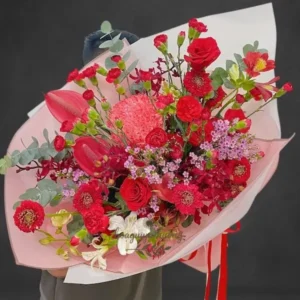 Bó hoa sinh nhật đẹp với tông đỏ nổi bật gồm hồng đỏ, mẫu đơn, lan đỏ và hoa baby.