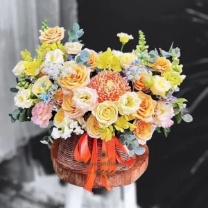 Giỏ hoa sinh nhật tặng đồng nghiệp màu vàng cam nhẹ nhàng, thiết kế thủ công trong giỏ mây.