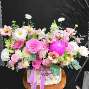 Giỏ hoa sinh nhật tặng vợ tông hồng pastel nhẹ nhàng, gồm hoa hồng, mẫu đơn, cát tường và thược dược nổi bật.