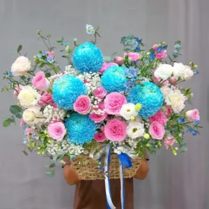 Giỏ hoa sinh nhật phong cách tinh tế với tone xanh dương – hồng pastel, nổi bật với hoa mẫu đơn xanh, hồng phấn và cẩm chướng trắng.
