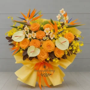 Giỏ hoa chúc mừng sang trọng với hoa thiên điểu, hoa hồng cam, hoa lan vàng, hoa môn trắng – thích hợp dịp khai trương hoặc chúc mừng.