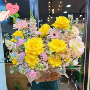 Giỏ hoa màu vàng pastel được thiết kế tại shop hoa tươi phục vụ ngày lễ.