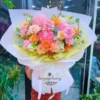 Shop hoa tươi theo mùa – Bó hoa cam hồng rực rỡ với giấy gói vàng tươi tắn