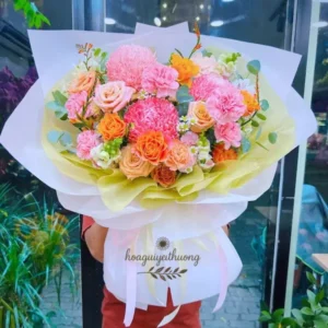 Shop hoa tươi theo mùa – Bó hoa cam hồng rực rỡ với giấy gói vàng tươi tắn
