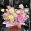 Giỏ hoa sinh nhật với sắc hồng và vàng pastel rực rỡ, được nâng niu bởi bàn tay người chồng, thay lời chúc mừng gửi đến vợ yêu.