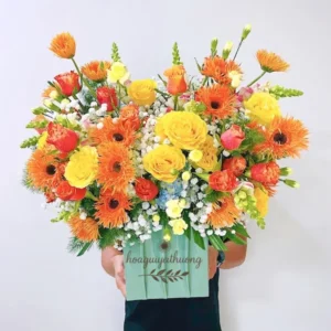 Giỏ hoa cam vàng lớn được cầm bởi người giao hàng từ shop hoa gần nhà.
