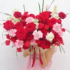Cô gái ôm bó hoa tươi rực rỡ gồm hoa hồng đỏ và cẩm chướng hồng từ shop hoa đẹp gần đây.