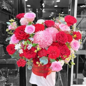 Giỏ hoa rực rỡ từ tiệm hoa tươi giao liền với sắc đỏ, hồng, tím, cắm tay đang được giao hàng.