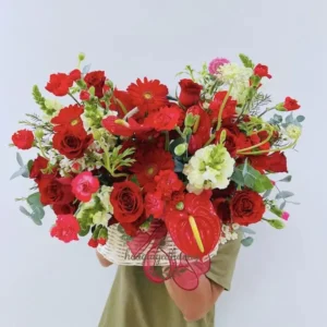 Giỏ hoa tươi nổi bật được cầm trên tay, nền sáng đơn giản