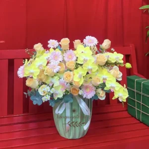 Bình hoa tươi chất lượng gần đây phối màu pastel nhẹ nhàng đặt trên bàn đỏ