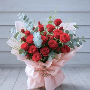 Nhân viên tiệm hoa gần đây đang thiết kế bó hoa theo yêu cầu với hoa hồng đỏ nổi bật trên nền hồng pastel, không gian tươi sáng và chuyên nghiệp.