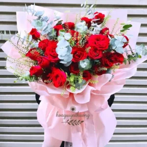 Bó hoa đỏ nổi bật tại tiệm hoa gần đây, được thiết kế theo yêu cầu với nhiều loại hoa tươi, nền trắng tinh tế.