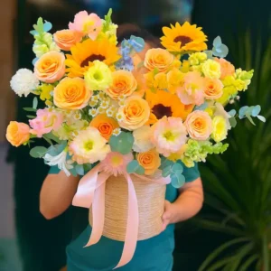 Một người đang cầm giỏ hoa rực rỡ trước tiệm hoa tươi gần đây nhất, phối màu cam, vàng và trắng.