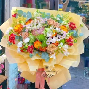 Bó hoa tươi chúc mừng rực rỡ với cam – đỏ – xanh từ shop hoa tươi chúc mừng Hoa Gửi Yêu Thương.